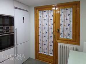 Cortina de frutas para cocina en una puerta de madera y cristal, sujeta con portavisillos